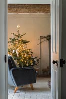 Christmas tree by armchair