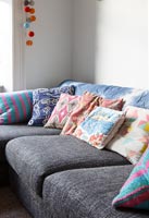 Colourful cushions on corner sofa