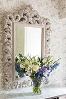 Vase of Larkspur and Peonies on console table