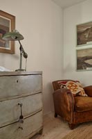 Leather armchair and wooden chest of drawers
