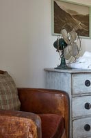 Leather armchair and wooden chest of drawers