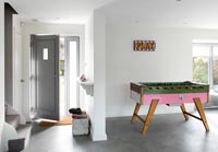 Entrance to open plan house with games table and concrete flooring