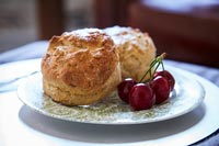 Scones and cherries on patterned plate