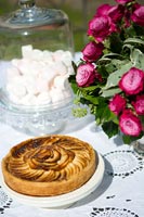 Apple tart on a table with floral arrangement