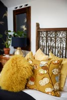 Yellow cushions with ornate bed frame