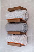 Rolled up towels stored on a wooden shelf