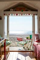 Interior of beach hut with view out to beach and sea