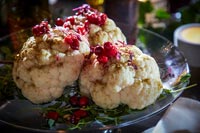 Roasted baby cauliflower with saffron, pomegranate and mint on glass serving dish