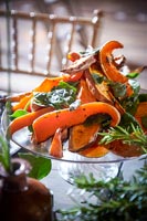 Detail of glass dish of sweet potato wedges with coriander crust 