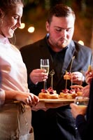 Woman serving canapes from a wooden board 