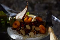 Fruit, nuts and cheese arranged on a glass dish