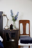 Detail of wooden bedside table and vintage chair