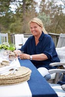 Woman with a drink at outside dining table set ready for entertaining