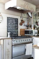 Cooker and ornate hood in fitted kitchen