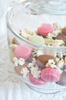 Detail of colourful macarons and popcorn in a glass bowl