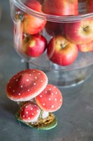 Detail of apples in glass jar and toadstool ornament