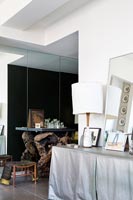 Fabric covered sideboard and mirrors in contemporary living room 