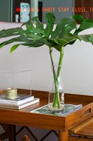 Vase of foliage on wooden roller table 