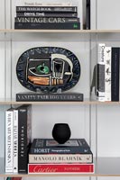 Modern bookshelves with books and decorative plate