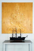 Decorative model ship and colourful Buddha painting 