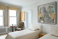 Twin beds in classic bedroom with modern artwork 
