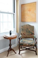 Classic armchair and side table by window 