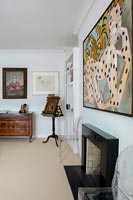 Antique cabinet in the bedroom with large modern art on wall