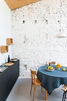 Modern dining room with painted brick wall