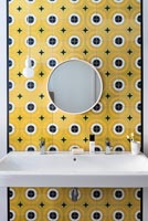 Bathroom sink with yellow and black tiled feature wall 