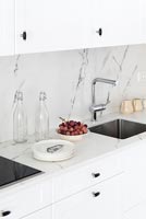 Black and white kitchen unit with sink and marble splashback