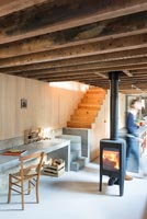 Lit wood burning stove in centre of modern living room 