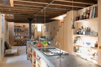 Concrete kitchen island in narrow open plan living area 
