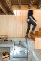 Woman walking up concrete and wooden staircase 