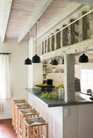 Barstools in modern country kitchen with exposed beams 
