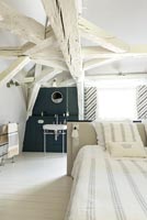 Country bedroom with white painted beams 