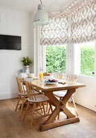 Wooden dining table in bay window 