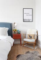Wooden armchair and artwork in modern bedroom 