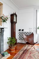 Grandfather clock and leather wing chair in eclectic living room 
