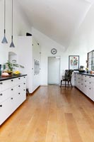Modern black and white kitchen with wooden floor 