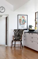 Chair with zebra blanket in modern black and white kitchen 