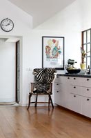 Chair with zebra blanket in modern black and white kitchen 