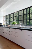 Modern black and white kitchen with view of trees through the window