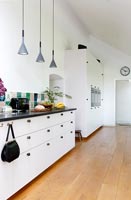 Modern black and white kitchen with wooden floorboards 