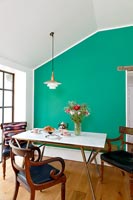 Dining area with green painted feature wall 