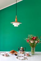Dining table with green painted feature wall 