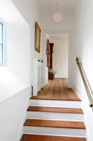 White and wooden staircase leading to landing 