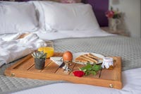 Breakfast tray on bed with bathrobe