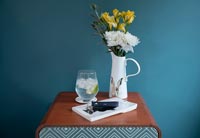 Bedside table with drink and vase