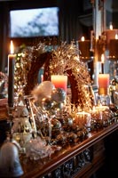 Candles and Christmas decorations on mantelpiece 