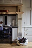 Pet dog in bed by aga in classic kitchen